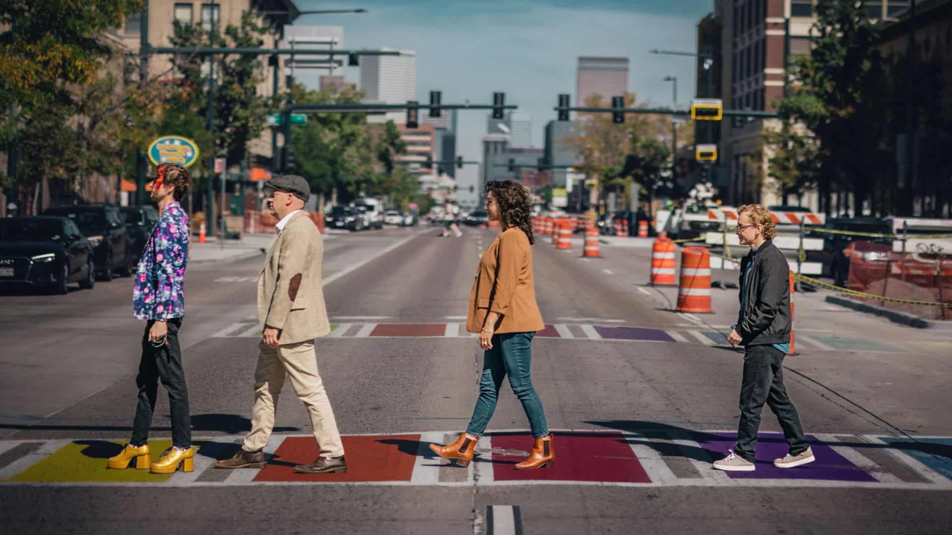 The 4 members of the band Avourneen cross a street walking along a crosswalk in formal clothes, imitating the Beatles' Abbey Road album cover,