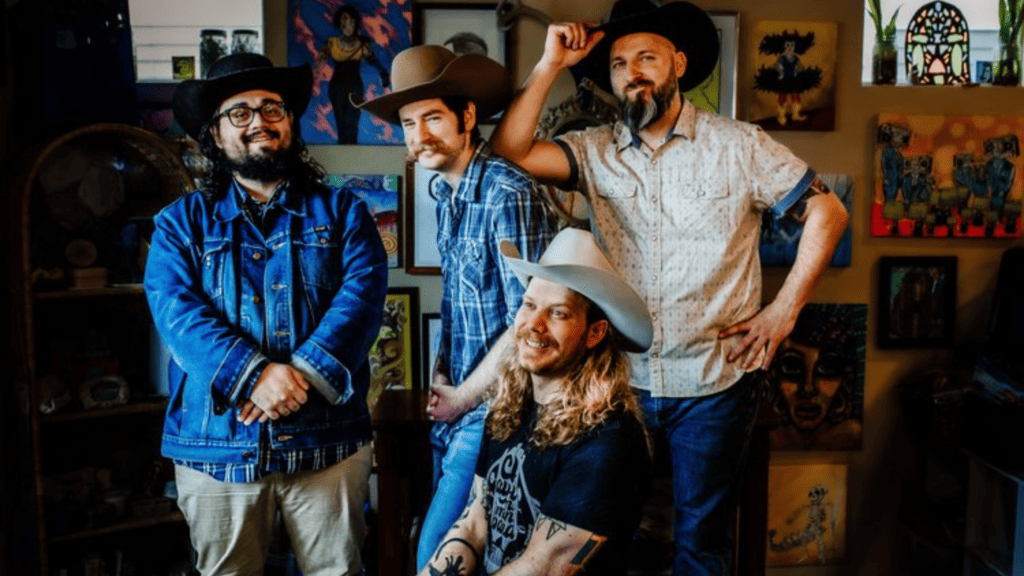 A photo of the 4 members of Sugar Britches, one of the bands performing at Four Mile Historic Park, wearing cowboy hats