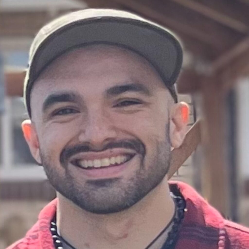A picture of Swallow Hill instructor Marcus Quintero smiling at the camera from behind a drumset