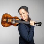 Ukulele player Brittni Paiva poses holding a uke over her shoulder.